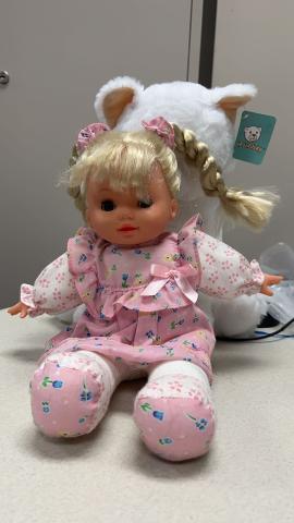 Blonde baby doll with a white long sleeve and pink floral dress