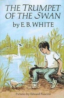 A young boy sitting on a log next to a lake that has a white swan