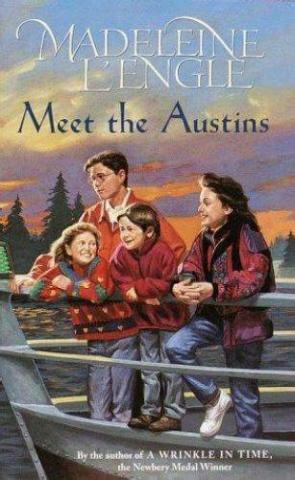 Four young kids that are at the nose of a boat looking out to the water