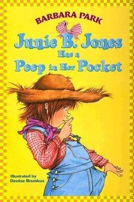 Junie B Jones is pulling her overalls away from her body and looking down at them with her finger to her lips in 'shhhh' fashion